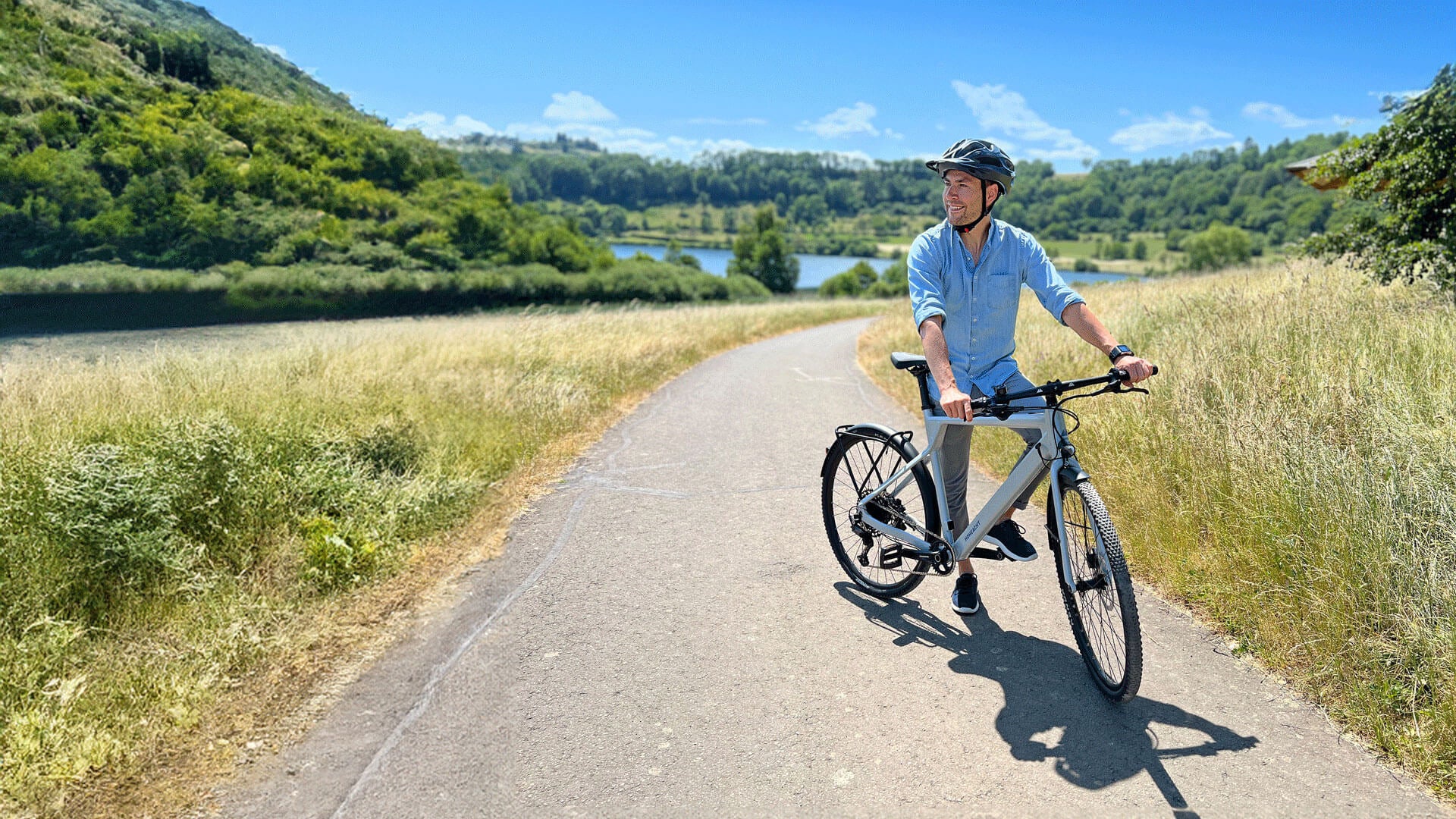 Gravelbiker stützt sich auf den Lenker seines Fahhrrads und genießt die Aussicht
