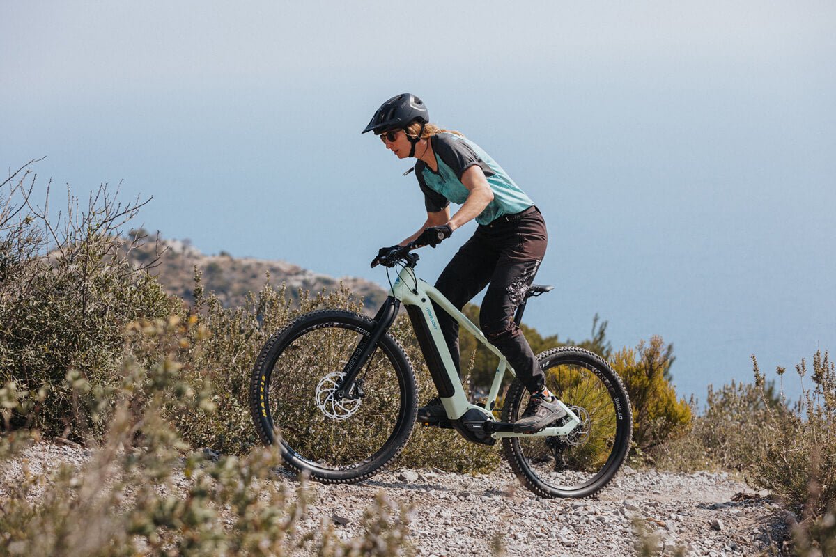 Mountainbikerin fährt steinige Piste bergauf