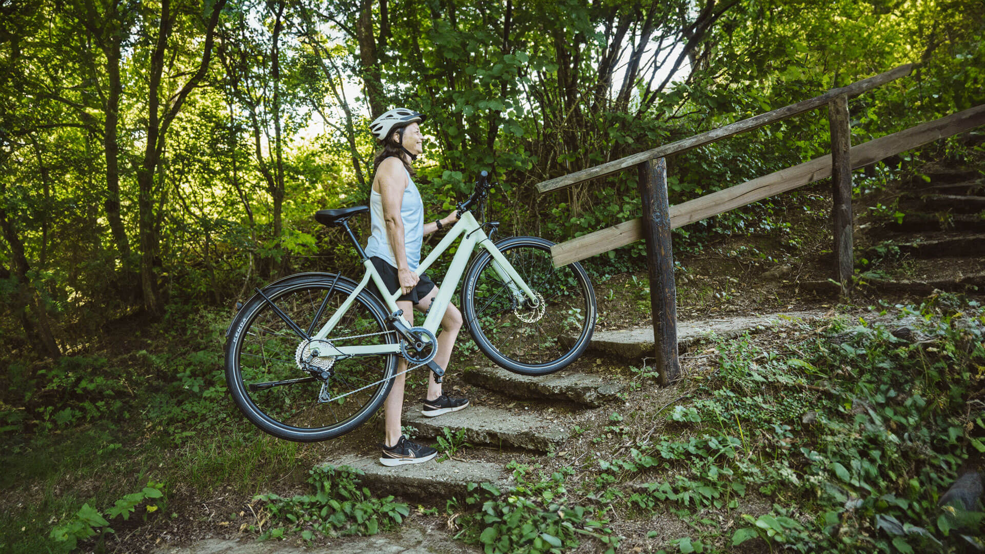 Bikerin trägt LUMO Tereno eine Treppe hoch